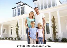 Young Family Standing Outside Dream Home