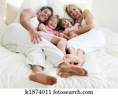 Family lying in bed smiling Family lying in bed smiling