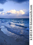 Ocean waves on beach at dusk