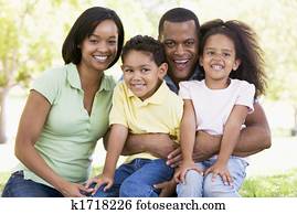 Family sitting outdoors smiling