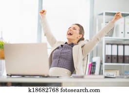 Portrait of happy business woman in office rejoicing success