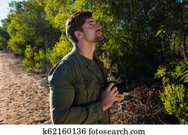 איש, עם, מצלמה, להסתכל, על ידי, עצים