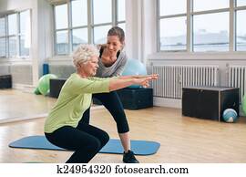 Elderly woman doing exercise with her personal trainer Elderly woman doing exercise with her personal trainer