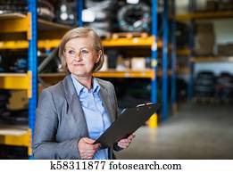 mulher sênior, armazém, gerente, ou, supervisor, com, clipboard.