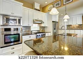 Kitchen room with granite tops and  white storage combination