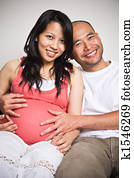Happy expecting pregnant asian couple