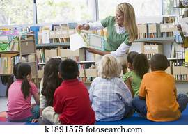 Kindergarten teacher reading to children in library Kindergarten teacher reading to children in library