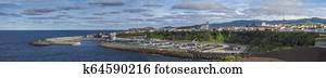 Panoramic View of colorful quay and port of village Rabo de Peixe with boats, church and lighthouse in Sao Miguel, the largest of the Azores Islands, Portugal. Sunny cloudy day