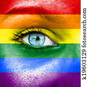 Woman face painted with flag of Pride