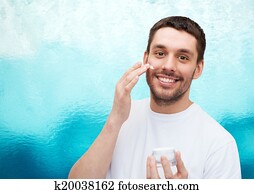 beautiful smiling man applyin cream beautiful smiling man applyin cream