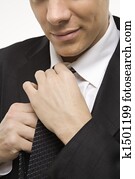Man straightening necktie.