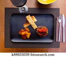 traditional spanish rissole with fried potato served on black plate on table