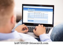 Man Filling Survey Form On Laptop Man Filling Survey Form On Laptop