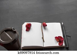 Top view of an empty notebook, scrapbook accessories and a cup of coffee on a black background. Top view of an empty notebook, scrapbook accessories and a cup of coffee on a black background.