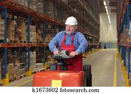 A senior worker driving the fork lift