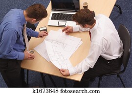 Two architects reviewing the blueprints