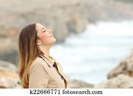 Woman breathing fresh air in winter on the beach