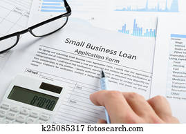 Hand With Pen And Calculator On Loan Application