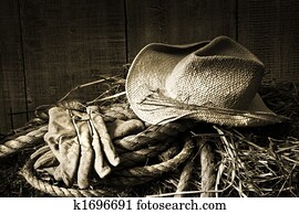 Straw hat with gloves on a bale of hay Straw hat with gloves on a bale of hay