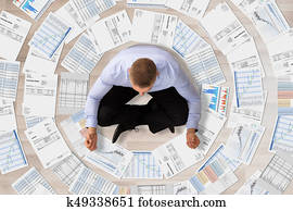 Businessman Doing Meditation Surrounded With Documents