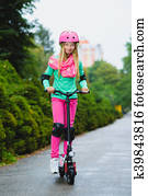 Happy girl riding on electric scooter outdoor