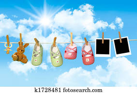 Baby shoes, pacifier and teddy bear on clothesline