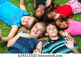 Diverse group og children laying together on grass.