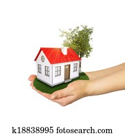 Hands holding a small house with land