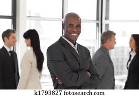 happy business leaderlooking at camera in front of team 