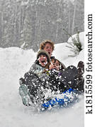 Teens sledding on a saucer Teens sledding on a saucer