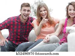 group of happy young people sitting on the couch