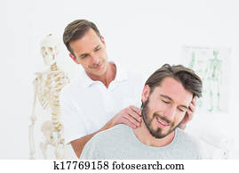 Male chiropractor doing neck adjustment Male chiropractor doing neck adjustment