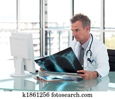 Middle aged doctor working at his Desk