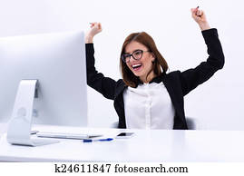 Excited businesswoman rejoicing at her success cheering and raising her fists in the air