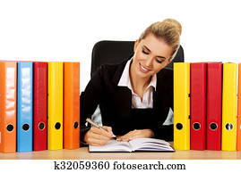 Smile businesswoman with binders by a desk