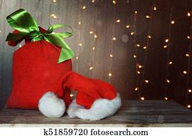כרטיס של חג ההמולד, עם, a, אדום, שקית, מלא, של, מתנות, ו, a, פפה נואל, hat., זוהר, גירלנדה, ב, ה, רקע.