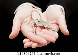 A real estate agent holding keys to a new house in her hands.