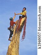 Team of rock climbers reaching the summit.