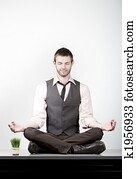 Handsome Young Businessman Meditating on Desk
