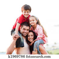 Parents giving children piggyback rides Parents giving children piggyback rides