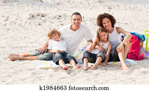 Family playing sitting on a beach