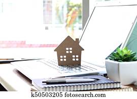 Wood house model on computer laptop