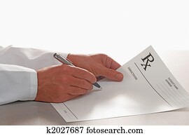 Doctor writing out prescription on RX form Doctor writing out prescription on RX form