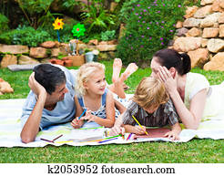 Happy family drawing in a park Happy family drawing in a park