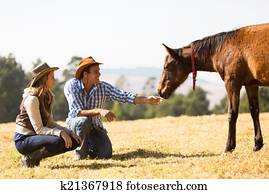 cowboy and cowgirl playing with foal cowboy and cowgirl playing with foal