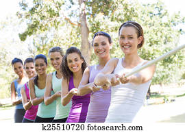 Fitness group playing tug of war