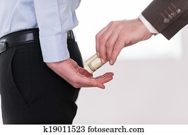 Giving a bribe. Close-up of businessman giving money to another man in formalwear Giving a bribe. Close-up of businessman giving money to another man in formalwear