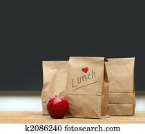 Lunch bags with apple on school desk Lunch bags with apple on school desk