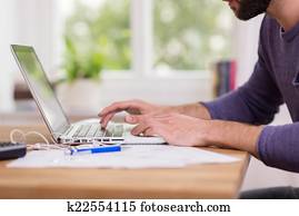 Man working from home on a laptop computer Man working from home on a laptop computer