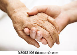 adult helping senior in hospital